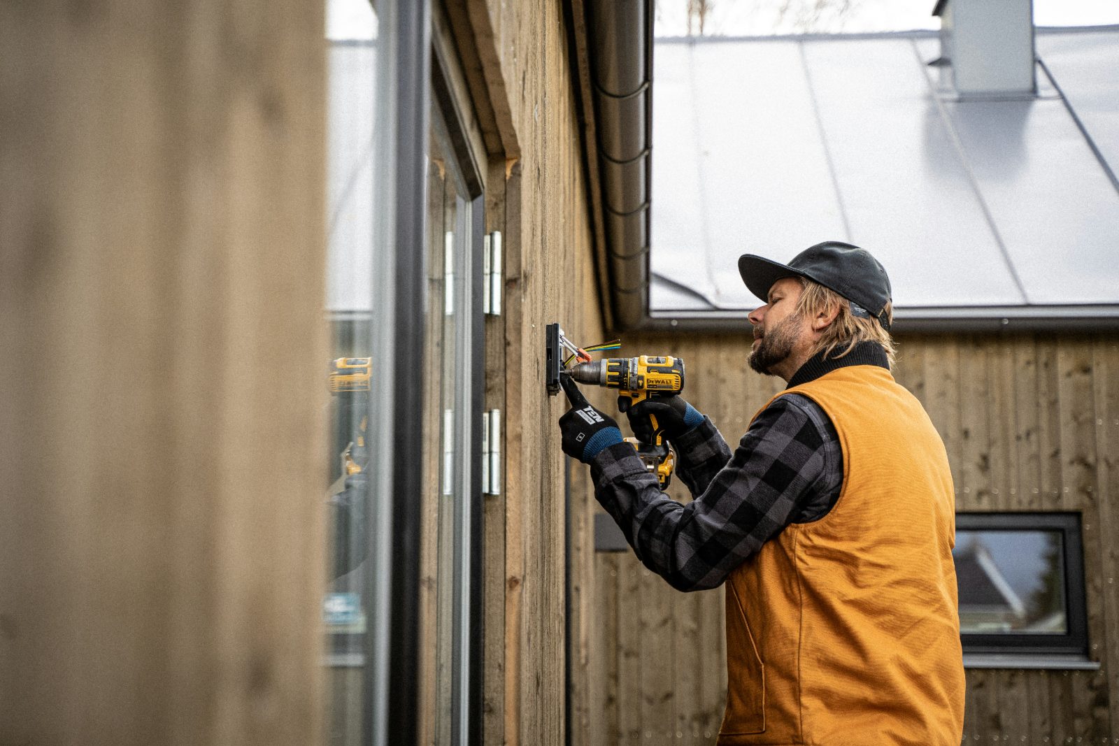 Monteur bringt einen Anschluss am Fenster an